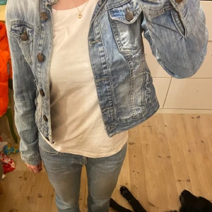 Jeansjacka - Jag säljer denna lite croppade jeansjackan! Den har två lagningar, men det är inget man tänker på eller ser från utsidan. 
