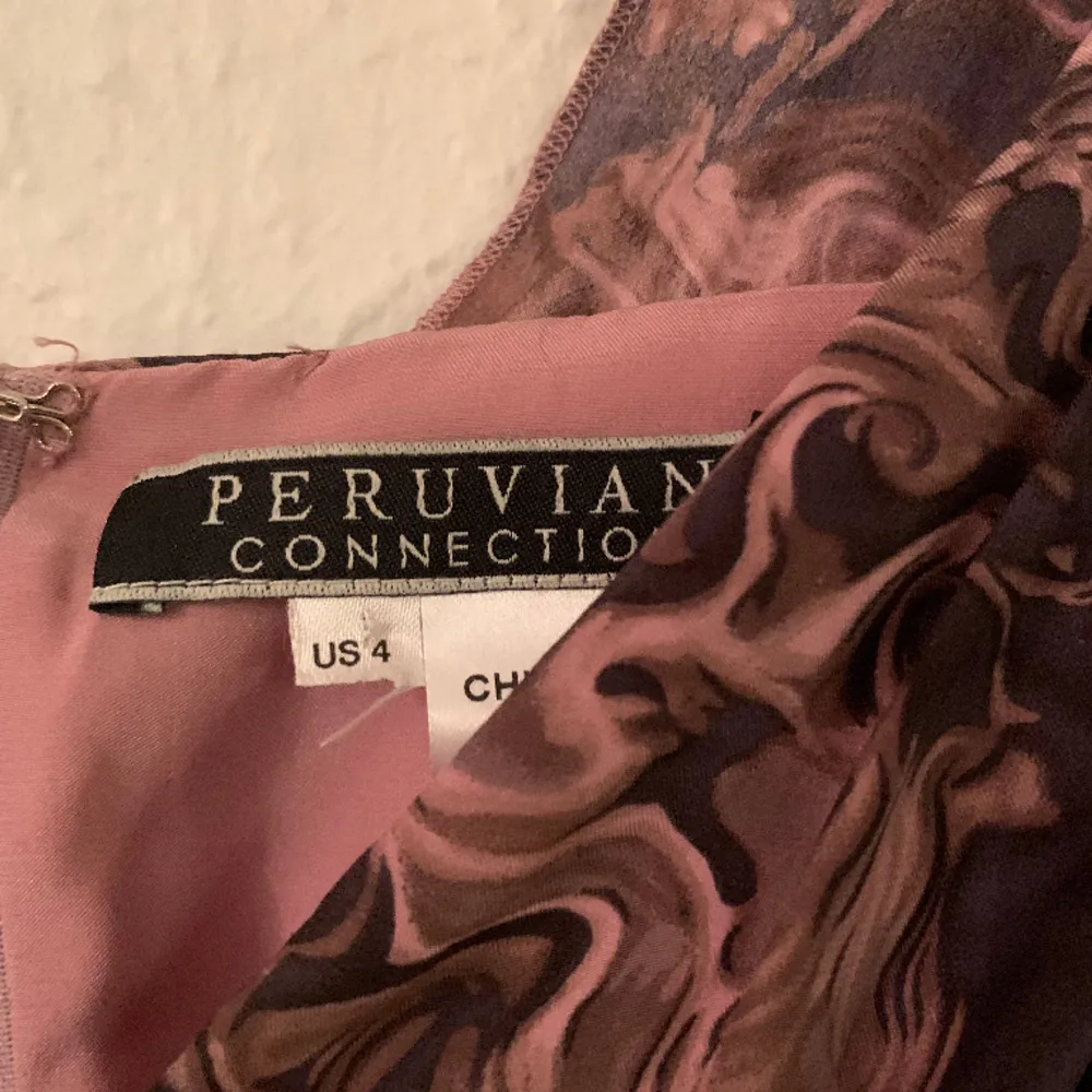 Party or cocktail dress, pure silk, fitted at waist, draping at front. Brand Peruvian Connection. New. Never worn. Lined. Dusty pink with deep grey motif. . Klänningar.