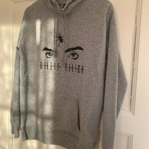 Luvtröja Billie Eilish - Ljusgrå luvtröja med Billie Eilish-tryck i storlek M men sitter mer som S.