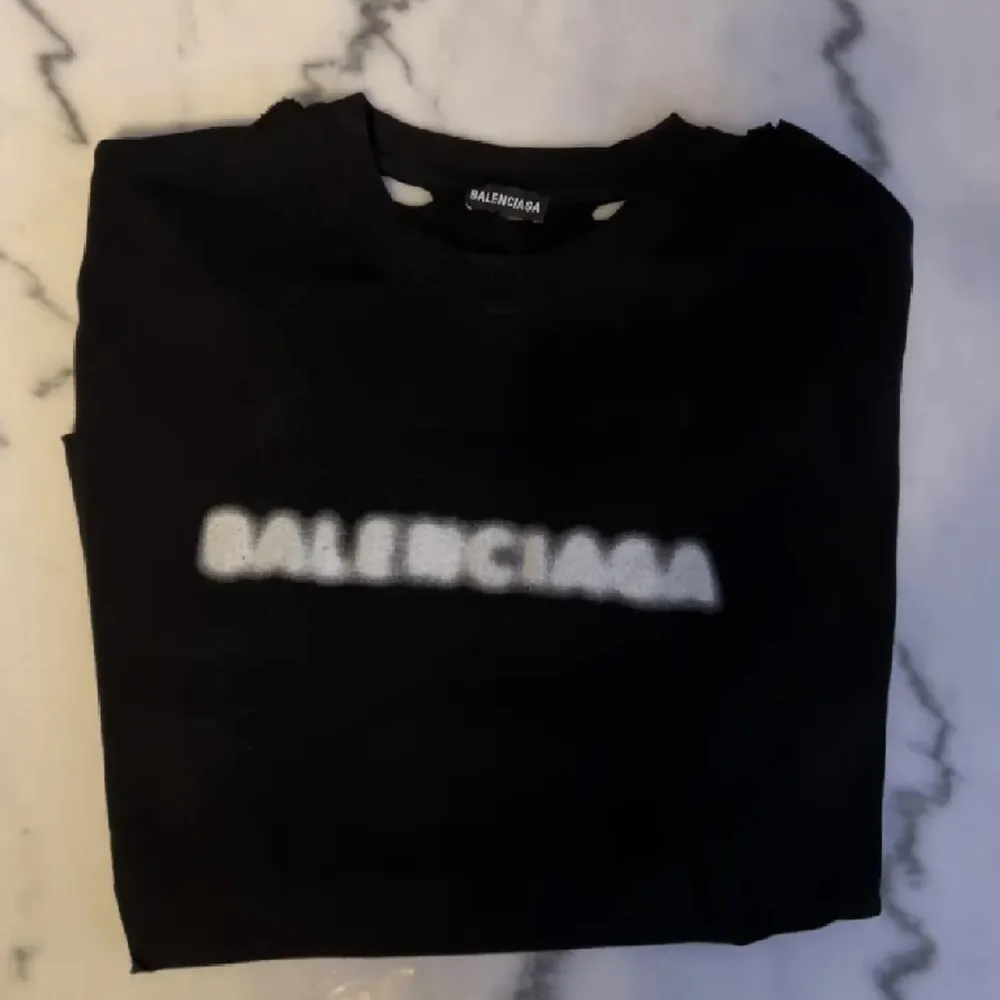 Balenciaga Black Blurred Logo Distressed T-shirt. Denna modellen är oversized och bredd i passform.. T-shirts.