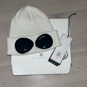Cp company mössa - Säljer nu min vita cp company mössa jag fick i julklapp förra året💕 endast använd Max 3 ggr, liten fläck på insidan men syns knappt, nyskick från nk sthlm, köpt för ca 1700?? Mina egna bilder 