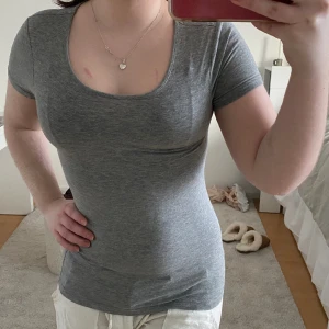 Basic grå tshirt tight - Fin passform och väldigt bekväm tight men stretchig T-shirt. Har för mycket basplagg så sällhet därför. Från tribute och är i fint skick även fast de är en mycket gammal tröja .