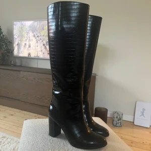 Stövlar- Tamaris - Endast testade!!! Superfina höga stövlar från Tamaris i ormimitation. Inköpta 2022 för 1200kr, aldrig använda endast testade. Fler bilder kan skickas.