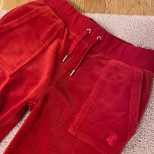Röda Juicy Couture Byxor - Röda Juicy Byxor i storlek S. Byxorna är i mycket bra skick. Det finns inga märken eller fläckar då de knappt är använda❤️