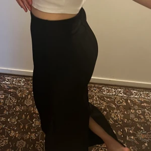 Kjol  - Strechig kjol i stl S, lång med en liten slits där bak. Bra sick. Ribbad material.