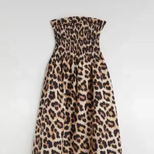 Supersöt smock-toppad klänning med leopardmönster. Ca 100 cm lång. Är fortfarande i nyskick! Nypris 199 kr. Avtagbara smala axelband medföljer som man kan justera och den är oanvänd. 100% bomull. 
