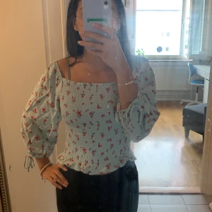 Fin topp - Säljer en fin topp som inte kommer till användning. Den är lite ljusgrön men ändå lite turkos. Har även mäster av blommor.