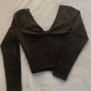 Svart långärmad croppad tröja - Mjuk svart croptop med långa ärmar. Den har öppen rygg och går att dra åt vid bysten, samt går att ha offshoulder. Jag klippte den själv så kanten rullar upp lite på botten. Skriv gärna till mig om du har frågor eller vill se fler bilder!<3