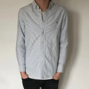 Ralph lauren skjorta  - Hej säljer denna blå randiga  Ralph lauren skjortan som är perfekt och stil ren nu på sommaren nu pris ca 1500 mitt 449 skick 10/10 bara lite skrynklig men de kan strykas bort storlek s
