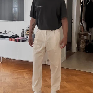 APC Renato Trousers - APC Renato Trouser Size: 46 Moderate carrot cut. Wide leg. Darts at waist on front. Offset buttoned tab closure. Zip fly. Side pockets. Back flap pocket. Worn twice / w with original bag