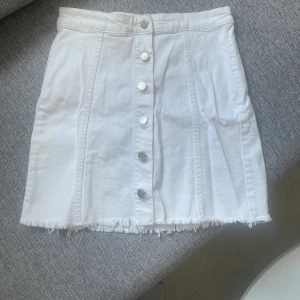 Vit Jeanskjol - Vit jeanskjol från Gina i storlek 38. Med knappt framtill