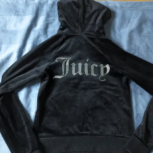Juicy couture hoodie svart - Säljer denna svarta velour zip up hoodie från juicy couture. Det finns inga tecken på användning och är i strl xs. Original pris 1200kr, men jag säljer den för 500kr.