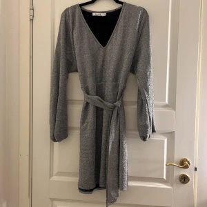 Klänning använd 1 gång från NA-KD - Klänningen är använd 1 gång och är köpt på NA-KD. Det är en midi klänning som slutar en bit ovanför knäna. Bältet är valfritt kan även dras bort. Materialet är skön och stretchig. Passar de flesta storlekarna. 