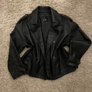 Skinnjacka (fejkläder) - (Fejkläder) Skinn/ läderjacka i näst intill nyskick. Super snygg och spexig passar perfekt mot våren! Den kommer med ett midjeband (se andra bilden) men fungerar lika bra utan. Jag skickar såklart med bandet oavsett 🩷