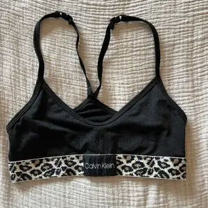 Bh / topp / bralette från Calvin Klein. Bra skick knappt använd. Svart med leopard detaljer. Storlekslappen har jag tyvärr klippt bort men jag uppskattar den att vara XS/S. 