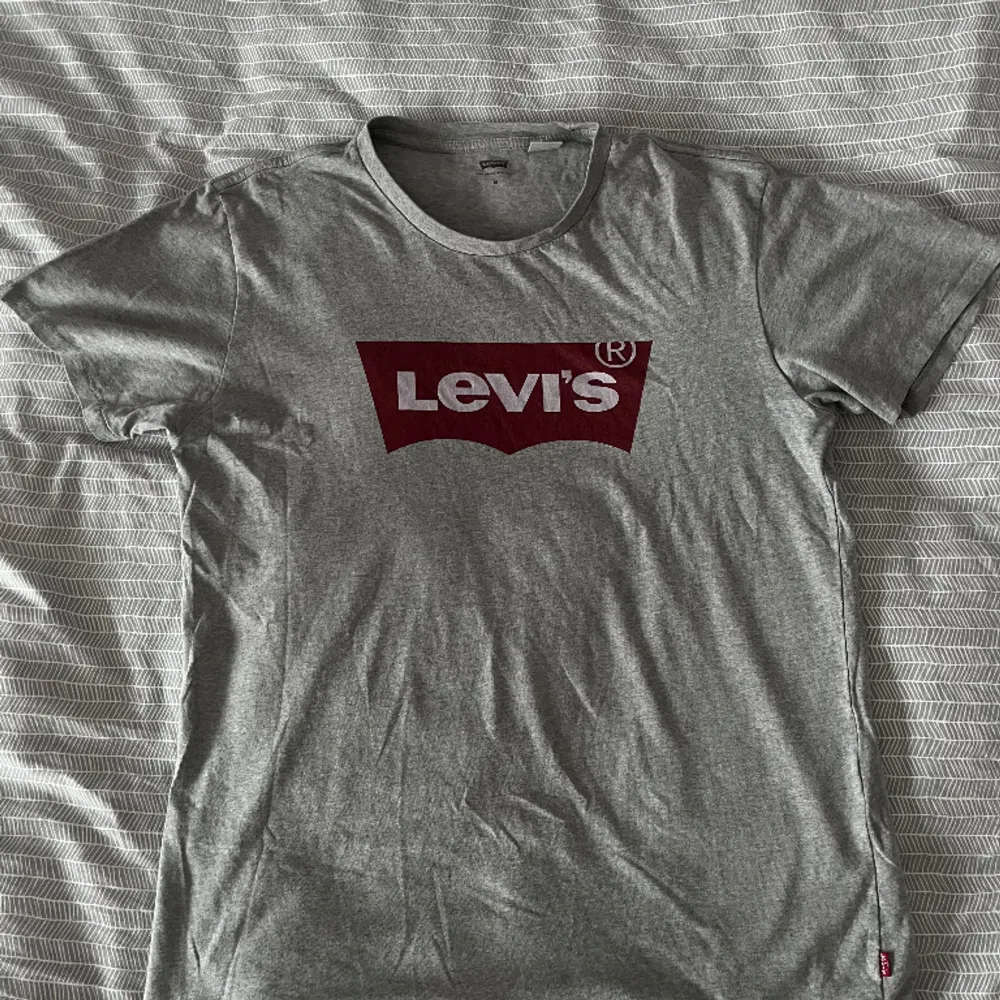 Ljusgrå Levi’s T-Shirt med tryck.  Nypris: 250kr  Skick: Mycket bra, sparsamt använd, inga synliga brister. T-shirts.