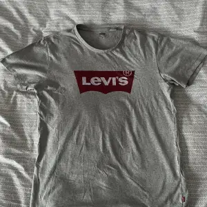 Ljusgrå Levi’s T-Shirt med tryck.  Nypris: 250kr  Skick: Mycket bra, sparsamt använd, inga synliga brister