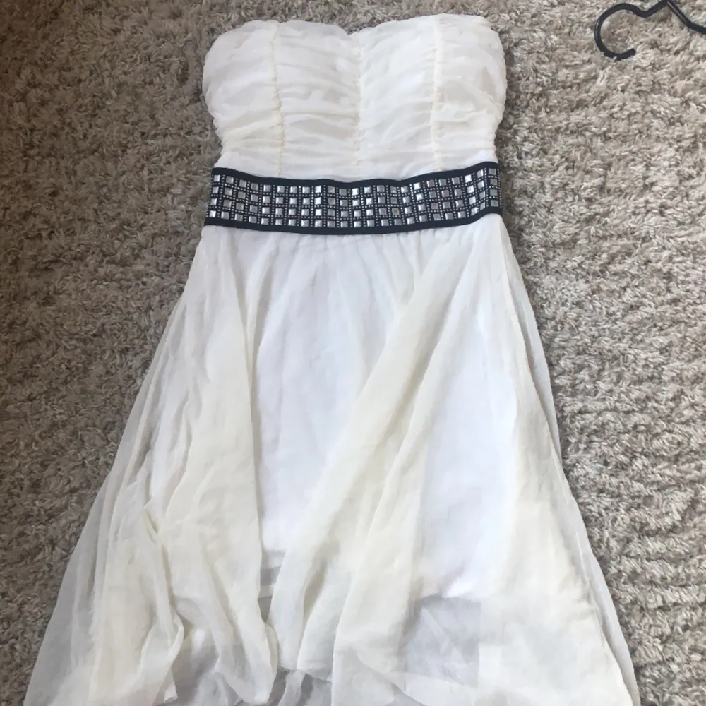 En vit fin somrig klänning med nitar runt midjan.Färgen har blivit lite mer gulaktig på de flesta ställena.Säljer då den inte sitter så bra på mig (S) Det är ett stretchigt material och har inga band. . Klänningar.