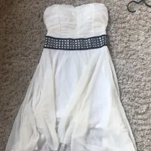 En vit fin somrig klänning med nitar runt midjan.Färgen har blivit lite mer gulaktig på de flesta ställena.Säljer då den inte sitter så bra på mig (S) Det är ett stretchigt material och har inga band. 