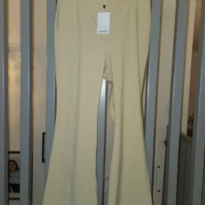 Sköna flared byxor  - Härligt stretchigt material på byxorna från Monki, sitter som en smäck. Blir inte skrynkliga eller noppiga. Ljusbeige i färgen. OANVÄNDA, prislapp kvar.  Strl 46