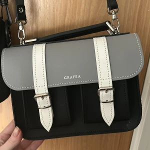 Axelremsväska från Grafea - I superfint skick. Endast märken av magneterna i lädret. Micro satchel från Grafea. Kostade runt 1000 kr ny från deras hemsida.