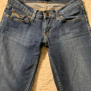 Säljer dessa super snygga mörkblåa lågmidjade Levis jeans! Midjemått: 36 cm innerbenslängd: 73 cm