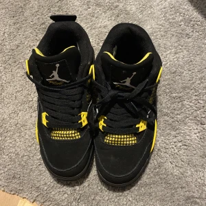 Jordan 4 thunder black/yellow ⚠️ Äkta⚠️ - Dom är inte så jätte använda men bara en flärp där back har dock gått sönder men annars jättebra skick knappt använda. Den trasiga flärpen finns med om man skulle vilja limma på den. Nytt pris 3000k 