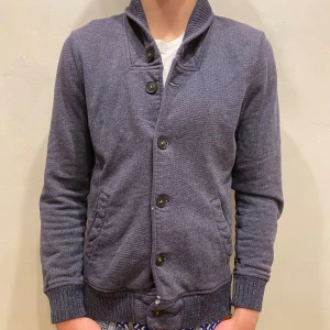 Kofta H&M - Kofta H&M Modell: 184cm & väger 84kg  Skick: allmänt använd, slitet för fram och vid ärmen  Färg: blå Material: bomull, polyester 