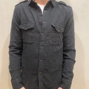 Skjorta Filippa K  - Skjorta Filippa K  Modell: 184cm & väger 84kg  Skick: allmänt använd, lite urtvättad  Färg: Svart  Material: 