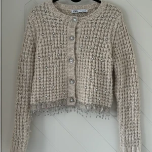 Stickad kofta/tröja  - Stickad tröja med stenar som kan användas både som kofta och tröja💗den är köpt från zara och är i storlek S. Den har inte kommit till användning så därför säljer jag. Skriv för fler bilder eller frågor💗(katt finns i hemmet)