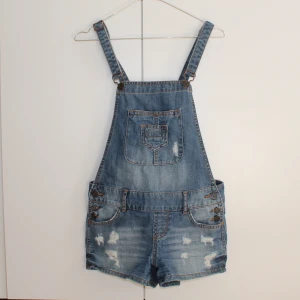 Hängslebyxor jeans  - Hängslebyxor i jeans Från New Yorkers kollektion "FB Sister" Liten skavank i form av att kanterna på fickorna ser använda ut, se bild 3, annars i gott skick 74% bomull, 26% polyester Skicka pm för mer info/samtal