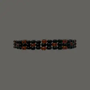 Hephaestus II Orange är ett snyggt armband uppbyggt av mörkorangea och svarta rocaillespärlor. Armbandet har en omkrets på cirka 18 cm men är töjbart.