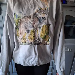 En sweatshirt med vargtryck I begangnat skick Storlek L (liten i Storlek)