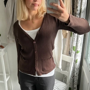 Brun ribbad kofta - Mörkbrun fint stickad ribbad tight kofta köpt secondhand. Står varken märke eller stl, men passar S/M! Mycket bra skick:) 