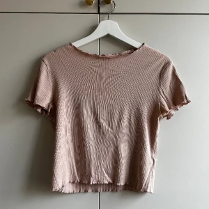 Puderrosa t-shirt - Puderrosa t-shirt med krusad kant. I använt men bra skick. 