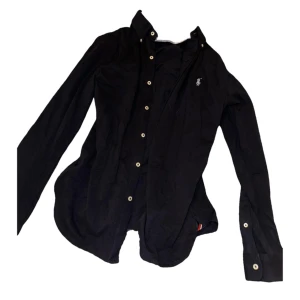 Ralph Lauren skjorta - Aldrig använd marinblå Ralph Lauren skjorta i featherweight mesh material, 100% bomull. Herrstorlek S, slimfit. Mått enligt hemsidan: Ärmlängd, 84 cm Bröstvidd, 104 cm Midjevidd, 102 cm Längd, 74 cm. Prislappen är kvar, nyskick. Köpt för 1599 kr.