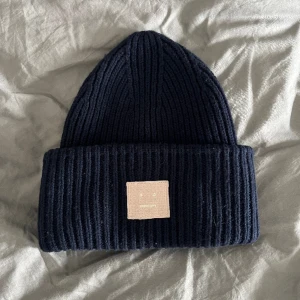 Acne Mössa - Säljer min Acne mössa som inte säljs längre. Den är marinblå med ljusrosa logga, och i väldigt fint skick 💖 Skicka ett meddelande för fler bilder eller frågor! Nypris är ca 1500:-