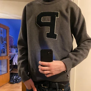 Ralph lauren sweatshirt - En Ralph lauren sweatshirt som är i ett topp skick då den inte är använd alls mycket, broderat P på tröjan i ” Teddy” material