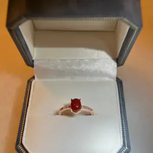 The ring is made of S925 silver with tag on it. Rose gold plated, genuine red jade, besides it are zircons. The Ring is adjustable size. Brand new, with jewellery bag provided 