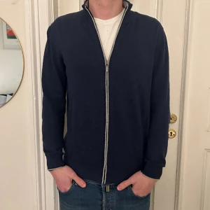 FULLZIP CASHMERE - Säljer denna riktigt sköna fullzip i cashmereblandning från märket Cortefiel. Tröjan är storlek M och helt ny med tags kvar👍Han på bilden är ca 185cm. Hör av er vid frågor eller funderingar!