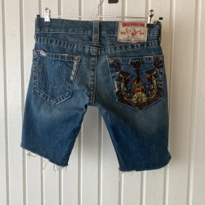 True Religion Jeansshorts  - Avklippta jeans från True Religion som blivit shorts. Äkta, ”made in USA”, nypris var över 4000 kr. Dessa har även broderi på bakfickan. Storlek 28. Sista bilden är bara en ”inspo bild” för fit’en. 