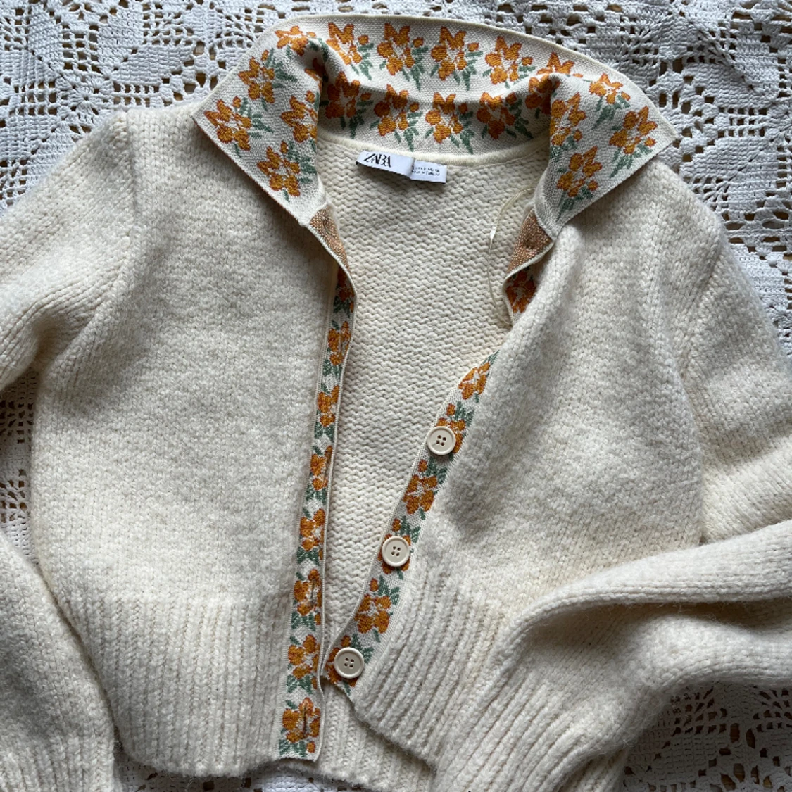 Stickad kofta med blommig krage