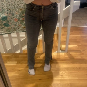 Gråa jeans med slits - Gråa jeans med slits från Zara. Jeansen är i strl 38 och är i ett bra skick. Jag säljer jeansen för dom är för små!❤️
