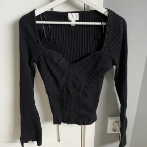 Svart stickad topp - En svart stickad topp från H&M. Urringad bekväm. Använd ca 8 gånger. Skulle säga att den passar M också men även större storlek då den är stretchig i materialet.