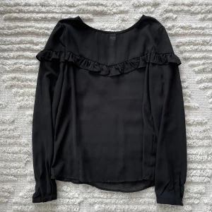 Blus  - Svart blus med volang