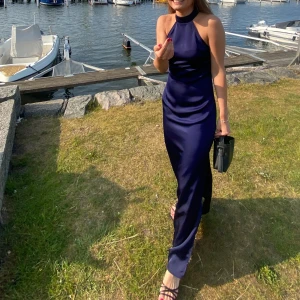 BALKLÄNNING - Säljer min superfina studentbalsklänning🤩Den är marinblå i satin från NA-KD och i väldigt gott skick! Har sytt in den i midjan så den är mer figursydd än den på hemsidan, dessutom en jättefin slits. Jag är 171 cm och hade 4cm klack på mig.