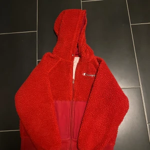 Champion jacka/hoodie - Röda snören finns till men tagit ur den ut jackan, men man får med dom. Knappt använd så rätt ny.