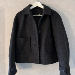 Vårjacka  - Säljer min korta kappa från Lager157. Jättefin både i modellen och färgen, använd flera gånger och köpt i höstas men i fint skick 🌼💕Mörkgrå/svart. Köparen står för frakten