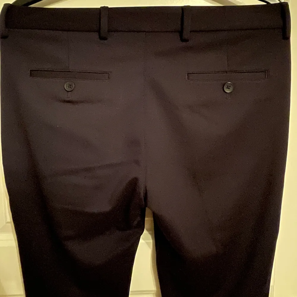 Svarta kostymbyxor från Jack & Jones. Två fickor framtill samt två fickor baktill, försluts med dragkedja och knapp.. Jeans & Byxor.