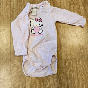Hello kitty body  - Säljer en hello kitty body till flicka storlek 56.